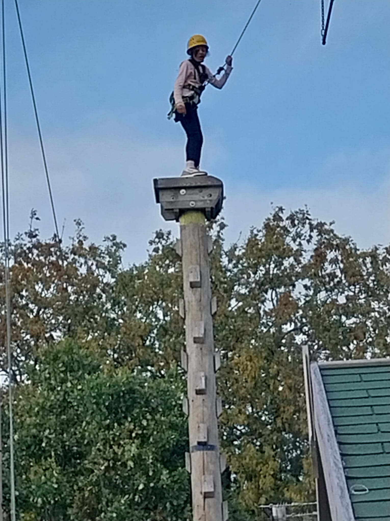 Girl standing on leap of faith pole about to jump